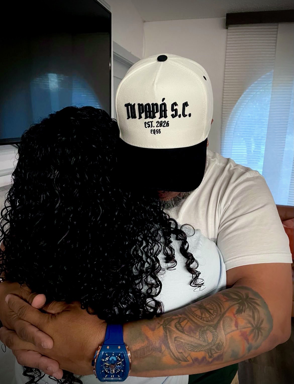 Papá abrazando a su hija con la gorra TPSC